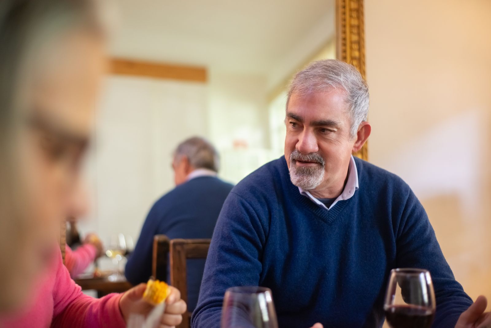 Senior man sharing a meal with companions at home in Cairo, GA