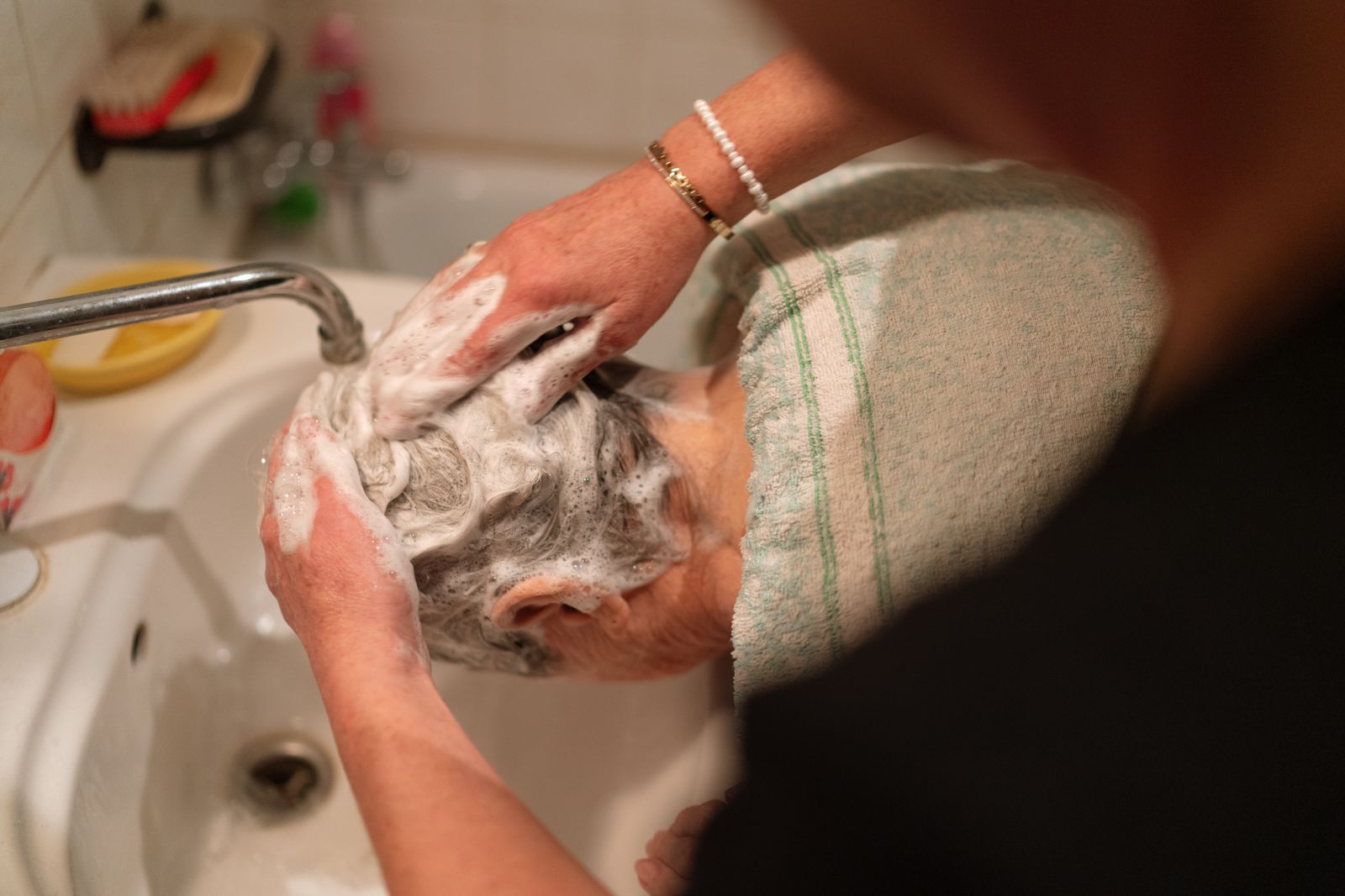Caregiver helping a senior woman with grooming at home in Cairo, GA